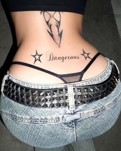 a woman's stomach with tattoos on it and the word dangerous written in cursive writing