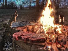 a grill with steaks and drinks on it