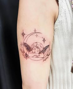 a woman's arm with an angel tattoo on the left side of her arm