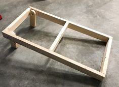 an unfinished bed frame sitting on the floor