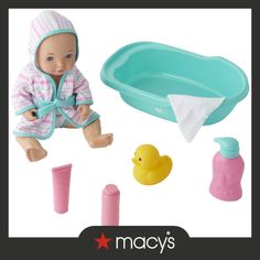 a baby doll sitting next to a bath tub and toy rubber duck