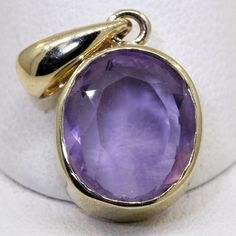 Exquisite 14 karat yellow gold pendant set with an oval-cut genuine amethyst measuring approximately 11.2 millimeters long by 9.16 millimeters wide and weighing an estimated 4.2 carats. The pendant weighs approximately 3 grams. It is stamped 14KT inside the bail, which a 2.83 millimeter opening for your chain. Excellent estate condition. Chain sold separately. We are listing several pieces of estate jewelry, along with other items fresh from fine North Carolina estates. We are happy to combine s Faceted Oval Purple Jewelry, Classic Amethyst Oval Pendant Jewelry, Gold Amethyst Oval Cabochon Jewelry, Oval Amethyst Jewelry With Polished Finish, Oval Amethyst Gemstones For Fine Jewelry, Polished Oval Amethyst Jewelry, Oval Purple Gemstones For Gifts, Purple Oval 14k Stamped Jewelry, Purple Oval 14k Gold Gemstone