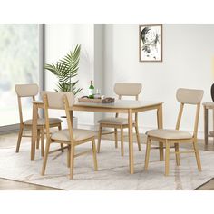 a dining room table and chairs with a rug on the floor in front of it