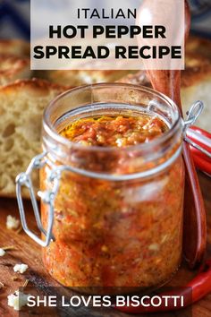 a jar filled with food sitting on top of a wooden cutting board next to bread