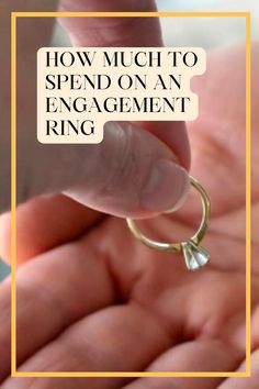 a hand holding a ring with the words how much to spend on an engagement ring