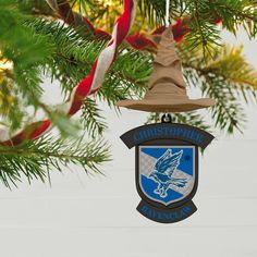 a christmas ornament hanging from a tree with a bell on it's side