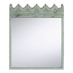 a mirror that is sitting on top of a white wall with an ornate border around it