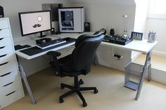 a desk with two computer monitors and a keyboard on top of it in a room