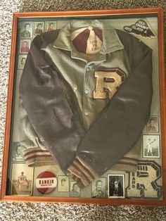 an old jacket is displayed in a wooden frame on the floor next to other memorabilia