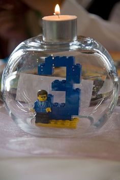 a lego man is in a glass bottle with a candle