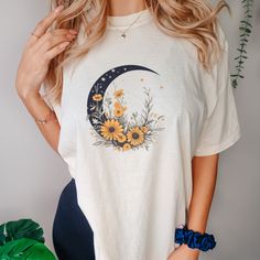 This Floral Crescent Moon Shirt is a soft-washed, garment-dyed fabric brings extra coziness to your wardrobe while the relaxed fit makes it an excellent daily choice. The double-needle stitching throughout the tee makes it highly durable while the lack of side-seams helps the shirt retain its tubular shape. .: 100% ring-spun cotton .: Medium fabric (6.1 oz/yd² (206.8 g/m .: Relaxed fit .: Sewn-in twill label Cotton Crew Neck Top With Moon Print, Trendy Cotton T-shirt With Moon Print, Trendy Spring Tops With Moon Print, Casual Spring Tops With Moon Print, Casual Moon Print Tops For Spring, Long Sleeve Cotton Tops With Moon Print, Casual Cotton T-shirt With Moon Print, Long Sleeve Cotton Top With Moon Print, Cotton Long Sleeve Tops With Moon Print