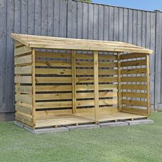 a wooden shed sitting on top of a lush green field