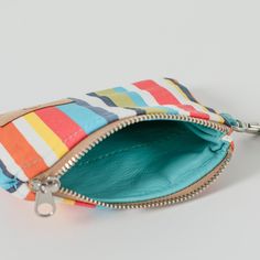 Experience luxury and style with this colorful striped, clip pouch. Its slim design allows for easy pocket access while providing ample space for your ID and cards. Add a touch of sophistication with the removable wristlet strap and carry it solo. Handcrafted by our team of women artisans in recovery, 100% of your purchase goes to provide job skills training and career development for the women who made it. Details 100% upcycled materials Dimensions: 5" x 4" Liner: Upcycled blue fabric Removable Multicolor Wristlet With Removable Pouch For Everyday Use, Multicolor Wallets With Cell Phone Pocket For Everyday Use, Everyday Multicolor Wristlet With Card Slots, Multicolor Wristlet With Card Slots For Daily Use, Multicolor Everyday Wallet With Zipper Pouch, Multicolor Pouch Wristlet For Everyday Use, Multicolor Everyday Wristlet With Removable Pouch, Everyday Multicolor Wallets With Zipper Pouch, Multicolor Wristlet With Removable Pouch