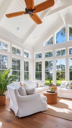 a living room filled with furniture and windows covered in wooden ceiling fan mounted to the ceiling