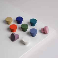 several different colored knobs on top of a white surface with no one around them