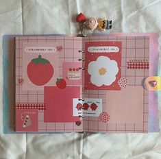 an open planner book with stickers and magnets on it's cover, sitting on a bed