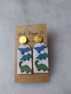 the earrings are made out of ceramic and have dinosaurs on them