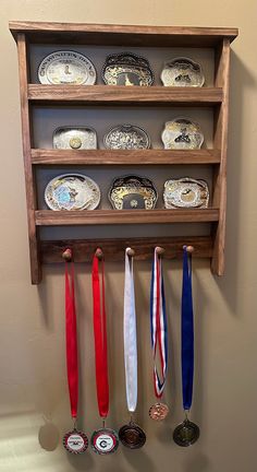 a wooden shelf with medals hanging from it's sides