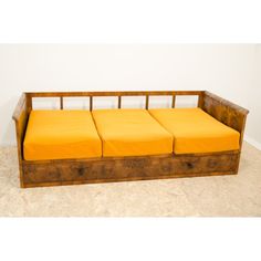 a wooden bench with four yellow cushions on it