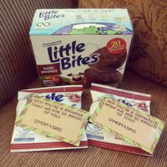 three little bites packets sitting on top of a couch next to a box of chocolate