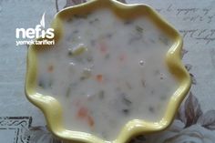 a yellow bowl filled with soup on top of a table