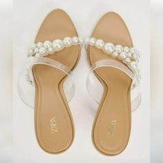 Heeled Vinyl Sandals With Faux Pearls. Color: Beige White Open Toe Jelly Sandals For Party, White Jelly Sandals With Round Toe For Party, Chic High Heel Jelly Sandals, Chic Closed Toe Jelly Sandals For Party, Trendy Spring Wedding Sandals, White Closed Toe Synthetic Jelly Sandals, Chic Flat Sandals With Padded Heel, White Closed Toe Jelly Sandals, White Flat Sandals With Heel Strap