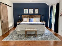 a bedroom with blue walls and wooden floors