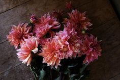 a bunch of pink flowers sitting on top of a wooden floor