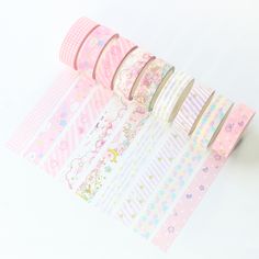 pink and white washi tapes lined up on top of each other with different designs