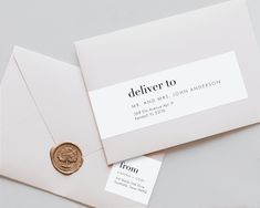 an envelope with a wax stamp on it and a gold seal sitting next to it