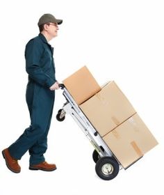 a man pushing a hand truck with boxes on it's wheels and wearing a hat