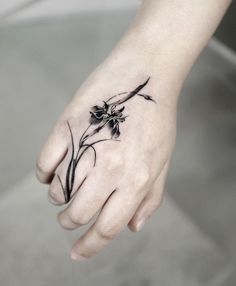 a woman's hand with a flower tattoo on it