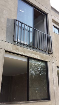 an apartment building with two balconies on the second floor and one window open