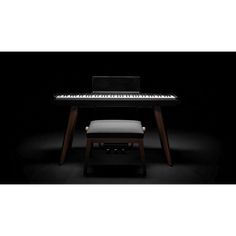 a piano sitting on top of a wooden table next to a white stool and black background