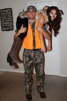 a man holding a woman in his arms while they are dressed up as deers