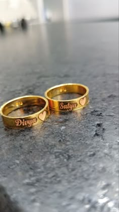 two gold wedding rings with the words divyo and stay together written on them