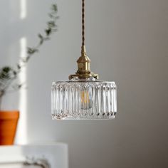 a glass light fixture hanging from a ceiling