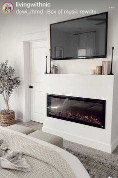 a white bedroom with a fireplace in the corner