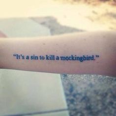 a person with a tattoo on their arm that says it's a sin to kill a mockingbird