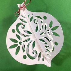 an ornament hanging from a string on a green background