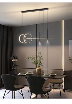 a dining room table and chairs with lights hanging from the ceiling