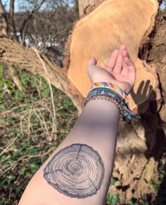 a person's arm with a tree ring tattoo on it