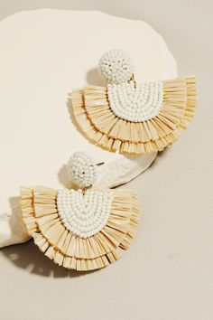 Add a playful touch to your outfit with these Ivory Raffia Fan Drop Earrings. These 1.75 inch earrings feature a fun raffia fan style made of white seed beads, sure to make a statement. With a stud backing, they are easy and comfortable to wear. 1.75 in Neutral, adds fun to any outfit! Lightweight White seed beads with raffia fan style Stud backing Ships FAST and FREE with all orders over $65! Raffia Earrings Diy, White Woven Beach Jewelry, Handmade White Beaded Earrings For Vacation, White Beaded Earrings For Summer Vacation, Handmade White Tassel Earrings For Beach, Tawny Autumn, Raffia Earrings, Beading Earrings, Fan Style