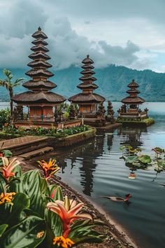 the water is full of flowers and some buildings with thatched roofs on top are surrounded by greenery