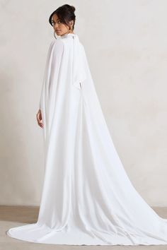 Exuding an angelic, ethereal mood, this aptly-named maxi dress was designed to see you through your big day. Crafted in a luxurious cream shade of our signature crepe, Saint arrives in a fully satin lined silhouette equipped with shaping seams that flow down your front and back. What transcends this piece is a couture-like chiffon cape that effortlessly flows behind you as you make your way down the aisle. Pair yours with our Just A Fling court shoes for a match made in heaven.   Features  - Premium crepe fabric - Premium chiffon cape - High neckline  - Self-tie collar - Princess seams - Invisible zip closure  - High leg split - Maxi length    Sizing & Fit  Model is 5'8 and wears UK size 8 / US size 4   Product Information     Fully lined with no stretch  Premium crepe in Cream (100% P White Gown With Cape Sleeves For Evening, Elegant Cape Sleeve Maxi Dress For Wedding, Elegant Maxi Dress With Cape Sleeves For Wedding, Pre-draped Floor-length Wedding Maxi Dress, Flowy Floor-length Evening Dress For Weddings, Flowing White Maxi Dress For Bridesmaids, White Chiffon Evening Maxi Dress, Flowy White Bridesmaid Maxi Dress, White Chiffon Maxi Dress For Evening