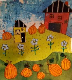 a paper plate with pumpkins and a house on the hill in front of it