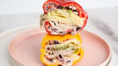 two stuffed peppers stacked on top of each other with cheese and vegetables in the middle