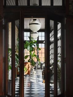 an open door leading into a room with potted plants