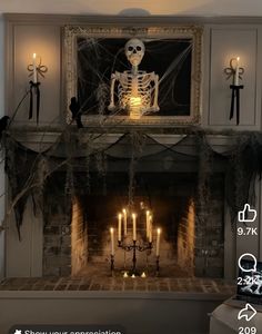 a fireplace decorated for halloween with candles and a skeleton on the mantel above it