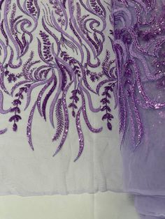 purple sequins and feathers on white fabric